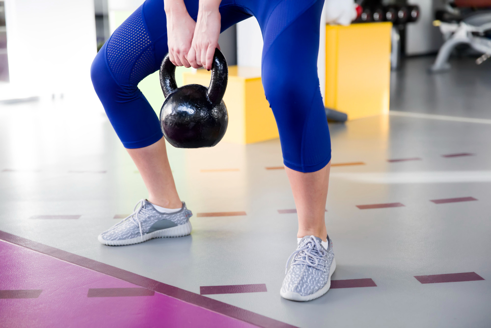 운동복을 입은 여성이 헬스장에서 케틀벨을 들어 올리는 모습. 저항성 운동은 근감소 예방에 가장 효과적인 운동 방식으로 주 2회 이상 권장된다.