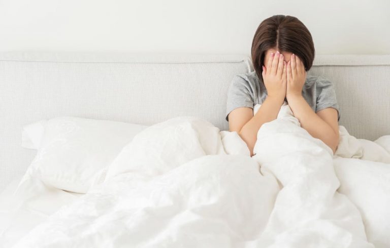 암 진단 후 불안과 불면증 - 침대에서 얼굴 감싸고 앉은 환자, 극심한 피로와 심리적 고통속에 있는 여성환자의 이미지