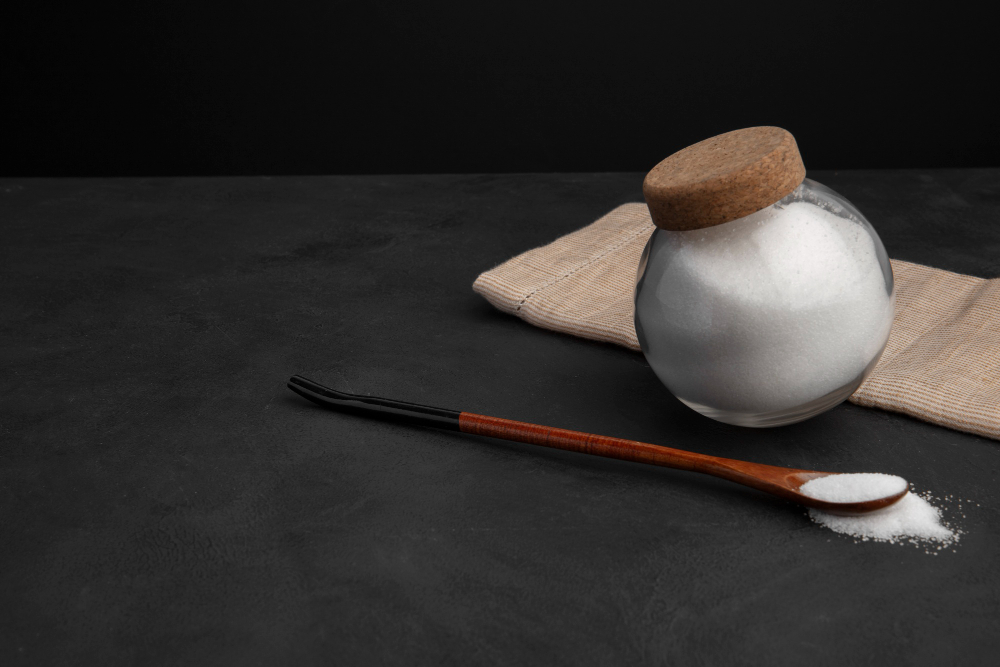 유리병에 담긴 소금과 나무 스푼 — 저염 소금(라이트 솔트)은 염화칼륨 함유로 고칼륨혈증 환자 반드시 주의 Salt in glass jar with wooden spoon – light salt and salt substitutes contain potassium chloride, must be avoided in hyperkalemia management