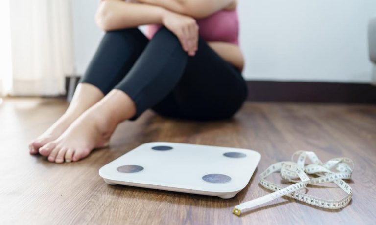 체중계 앞에 앉아 요요를 걱정하는 여성 — 마운자로 치료 후 체중 유지 방법