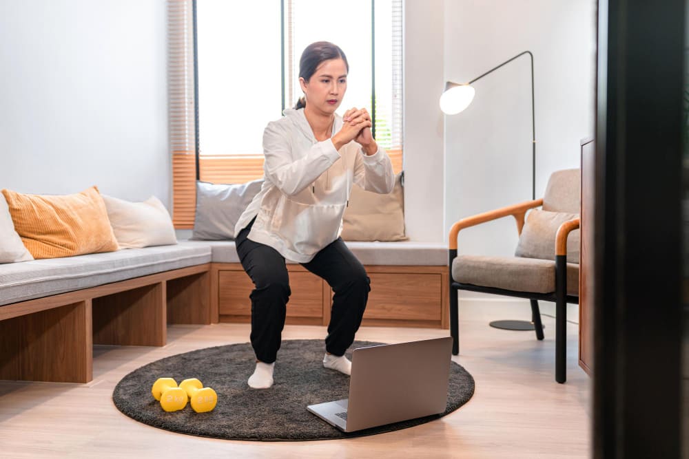 마운자로 요요 방지를 위해 집에서 스쿼트 홈트레이닝을 하는 중년 여성 — 저항운동 루틴 시작