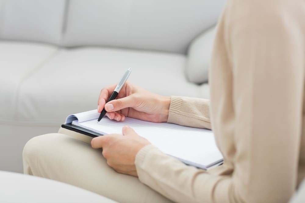 폭식 충동이 왔을 때 이유를 한 문장으로 기록하는 여성 — 식욕 충동 언어화 전략EnglWoman writing one-sentence note when food craving strikes — journaling as a behavioral tool for appetite control after weight loss